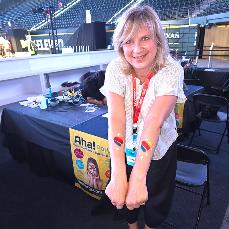 Southwest Airlines Rally 26 at Globe Life Field- Beautiful lady showing off the Southwest Logo airbrush tattoo on her arm.